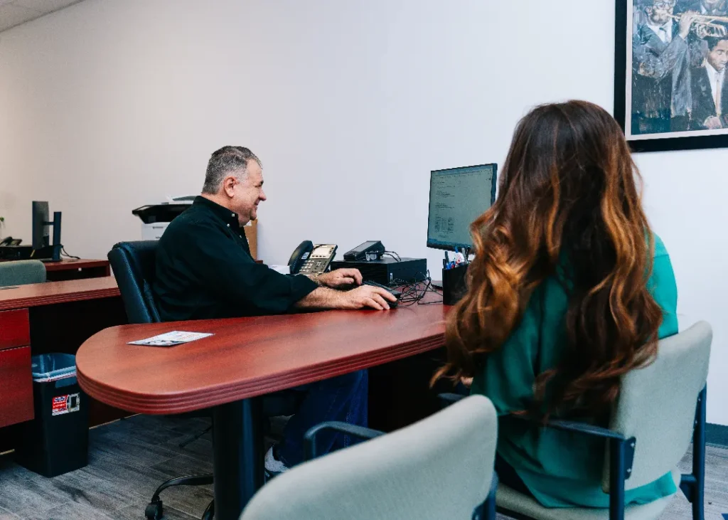 title authority lou at desk with client