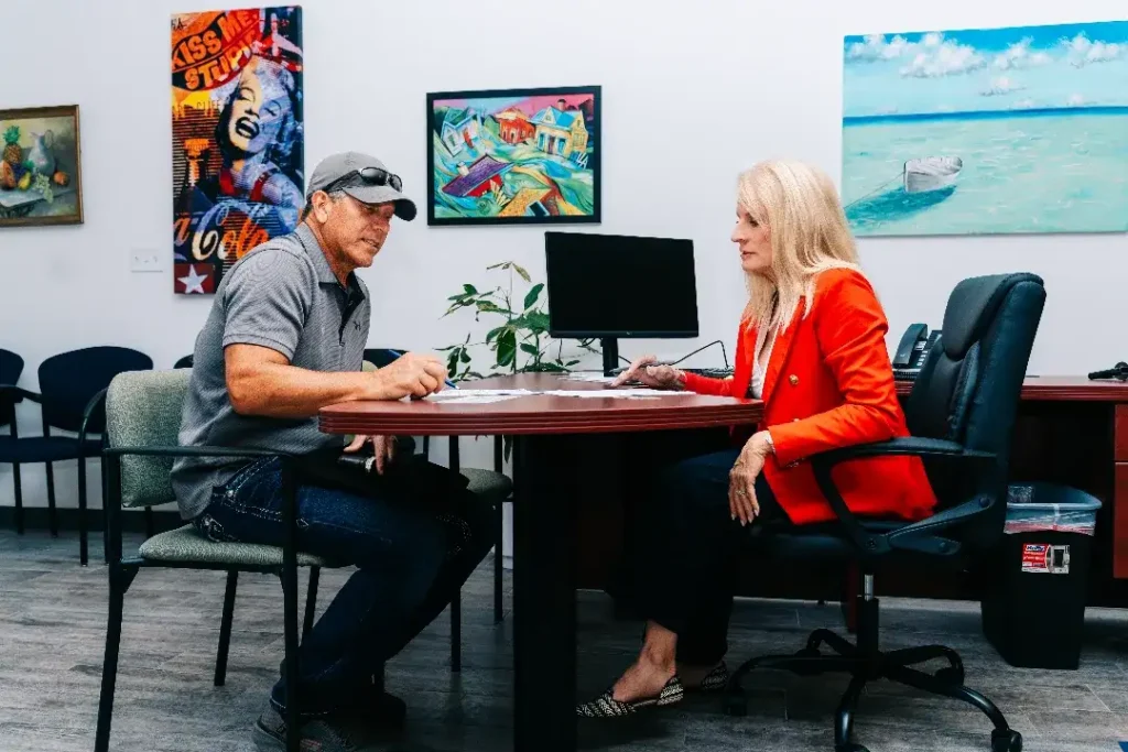 man and woman reviewing documents for vehicle title transfer